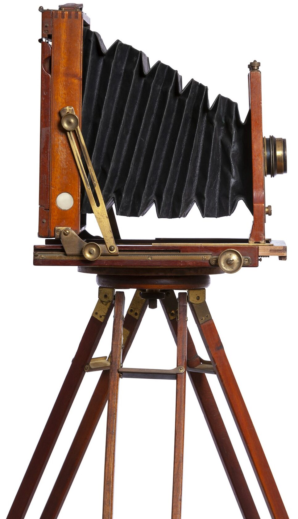 Side view of an antique bellows camera on a tripod isolated on a white background